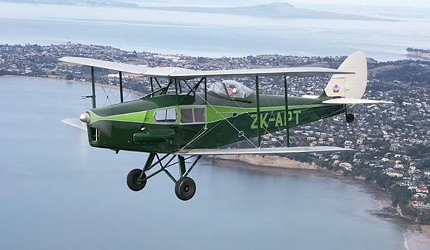 FLYING FOX: The newly restored DH83 Fox Moth past Whangaparaoa Peninsula near its North Shore home base. — JOHN KING.