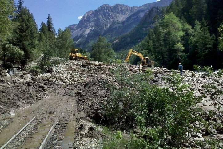 Heavy equipment is used to clear mud and rocks from train tracks about 10 miles south of Silverton. A mudslide reported Tuesday, August 02 between Needleton and Elk Park forced the Durango & Silverton Narrow Gauge Railroad to cancel its runs to Silverton until Sunday, August 07. More problems from mudslides were discovered Wednesday. — Photo: Courtesy of Durango & Silverton Narrow Gauge Railroad.