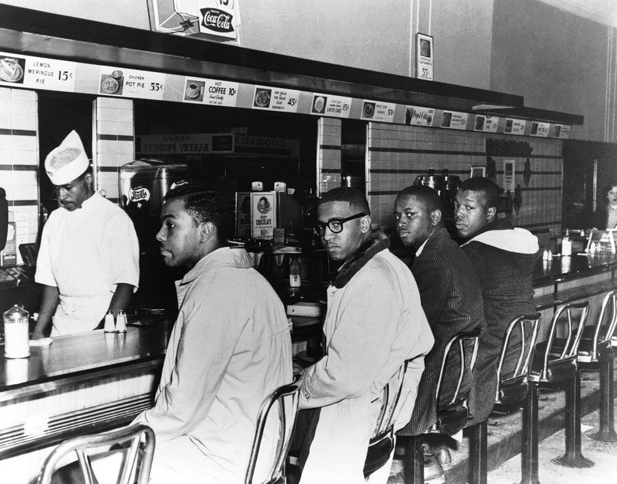 Franklin McCain, second from left, and friends sit at the Woolworth's lunch counter in Greensboro, North Carolina, on the second day of black students' efforts in 1960 to desegregate the counter. — Photo: John G. Moebes/Corbis Images.