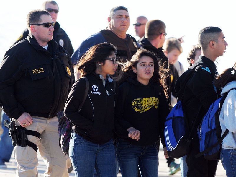 Students surrounded by police are escorted from Berrendo Middle School after a shooting on Tuesday in Roswell, New Mexico. Roswell police said the suspected shooter was arrested at the school. — Photo: Mark Wilson/Roswell Daily Record.