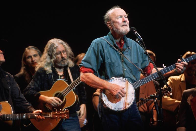 Seeger plays the banjo and sings with Arlo Guthrie, back left, at the Woody Guthrie Tribute Concert at Severance Hall in Cleveland in September 1996. — Photo: Neal Preston/Corbis.