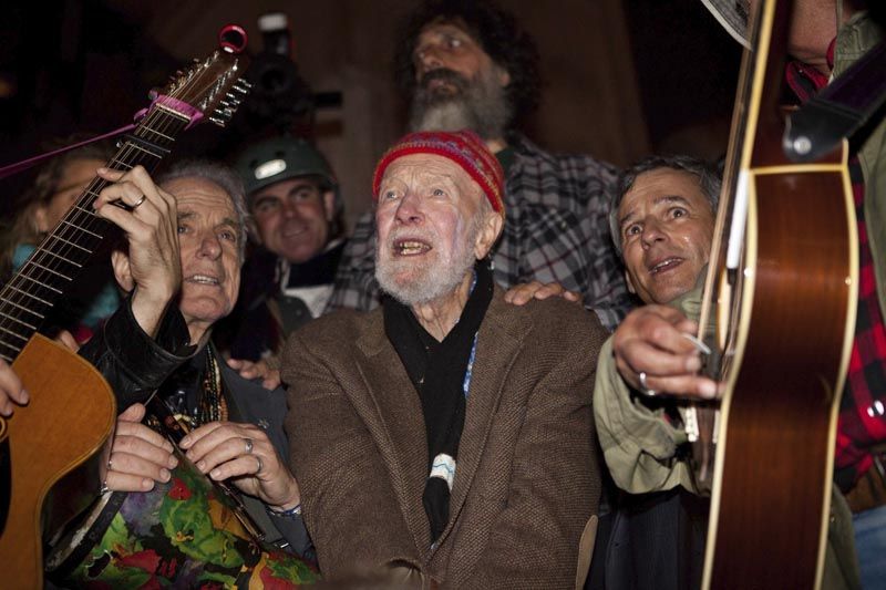 Pete Seeger, center, sings before a crowd of nearly a thousand demonstrators sympathetic to the Occupy Wall Street protests at a brief acoustic concert in Columbus Circle in New York on October 21st, 2011. — Photo: John Minchillo/Associated Press.