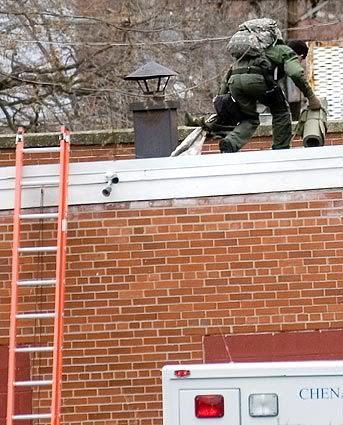 A sniper takes a position on a roof near the American Civic Assn. in downtown Binghamton, N.Y. (Rebecca Catlett/Press & Sun-Bulletin)