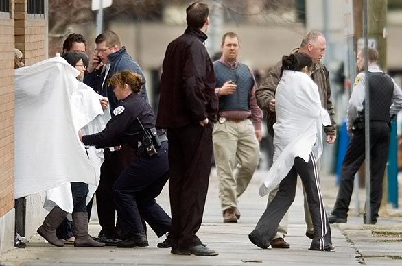 Hostages exit a building near the American Civic Assn. in downtown Binghamton, N.Y., after a shooting spree by a gunman. (Rebecca Catlett/Press & Sun-Bulletin)