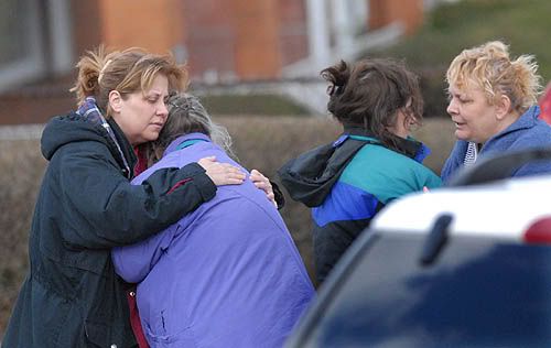 Family members of the suspect in this morning's deadly standoff offer each other comfort at the scene. Tony Tye/Pittsburg Post-Gazette.