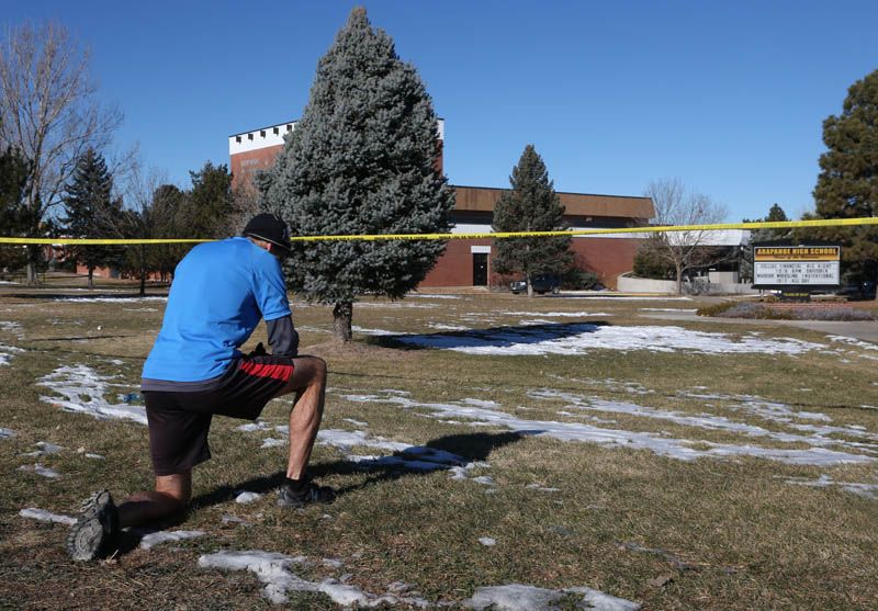 Sean Sweeney, a runner who lives near Arapahoe High School in Centennial, Colorado, pauses Saturday to say a prayer outside the school that was terrorized by a gunman on Friday. — Photo: David Zalubowski/Associated Press.