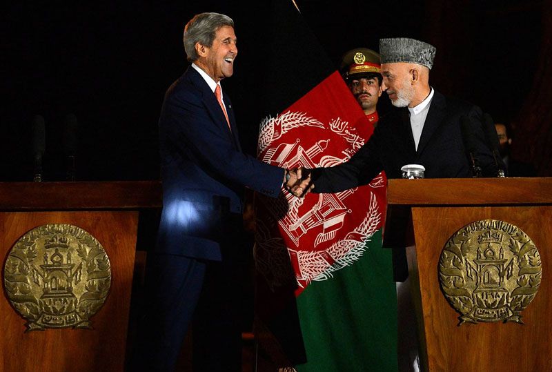 U.S. Secretary of State John F. Kerry greets Afghan President Hamid Karzai during their joint news conference after their talks in Kabul, the Afghan capital.  Photo: Massoud Hossaini/AFP/Getty Images/October 12th, 2013.