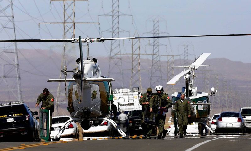 Helicopters and police vehicles block U.S. 395 in Central California south of Ridgecrest where officers killed a gunman after an hourlong chase. Two wounded people were found in the trunk of the fleeing car.  Photo: Irfan Khan/Los Angeles Times/October 25th, 2013.