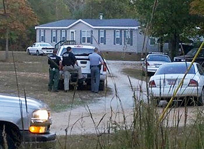 Law enforcement officials stand near a home on Callison Highway where six people were found dead, on Tuesday in Greenwood, South Carolina. — Photo: Matt Bruce/Associated Press/October 30th, 2013.