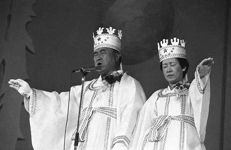 The Rev. Sun Myung Moon and his wife, Hak Ja Han, are shown during the traditional invocation of a blessing at a mass wedding in Seoul's Chamsil gymnasium, where 6,000 couples from about 80 countries were married.  Photo: Associated Press/October 14, 1982.