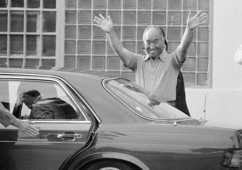 The Rev. Sun Myung Moon smiles and waves as he leaves the Federal Correctional Institution in Danbury, Connecticut, where he was jailed on tax evasion charges. He left Danbury to serve the remainder of his sentence at a halfway house in Brooklyn, New York.  Photo: Bob Child/Associated Press/July 04, 1985.