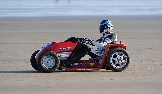 CUTTING THE SAND: Don Wales broke the record, after first cutting a patch of grass to prove he was riding a lawnmower, recording an average speed of 138.5km/h.  Photo: Associated Press.