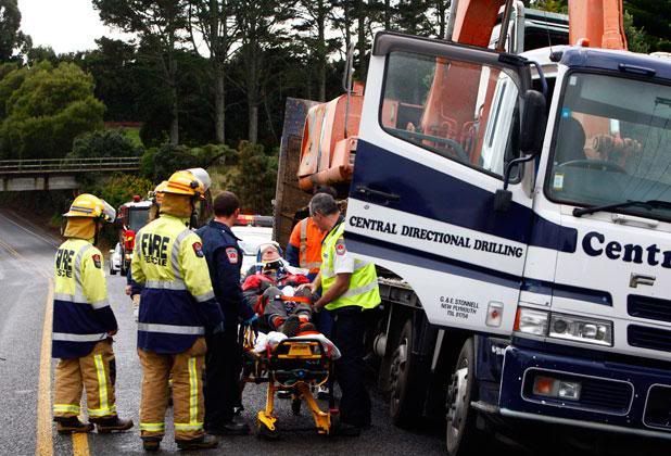 THAT HURT: Paramedics place the injured truck driver on a stretcher following Tuesday's bridge crash.  ROBERT CHARLES/Taranaki Daily News.