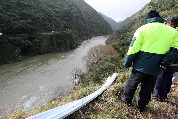 Emergency workers look down the cliff where a car crashed this morning. — FAITH SUTHERLAND/Manawatu Standard.