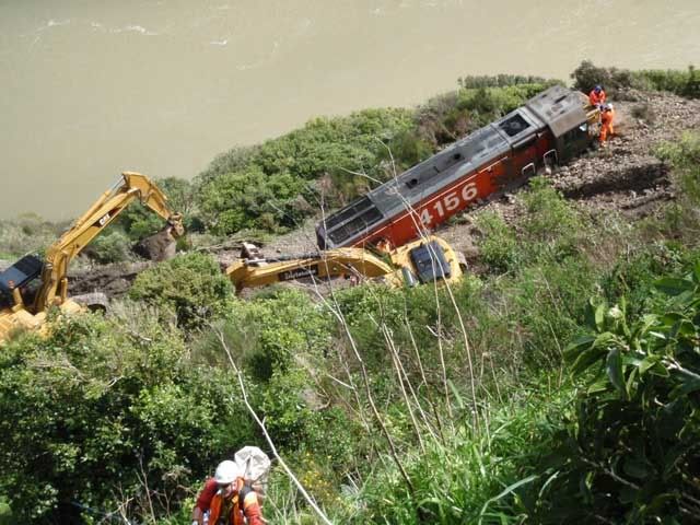 CLEANING UP: Diggers working around the crashed locomotive on the slip in the Manawatu Gorge.