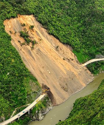 LANDSLIDE: Workers using heavy machinery attempt to clear the Manawatu Gorge yesterday. The road was blocked when 20,000 cubic metres of rubble was brought down by rain last month. — Photo: NZTA.