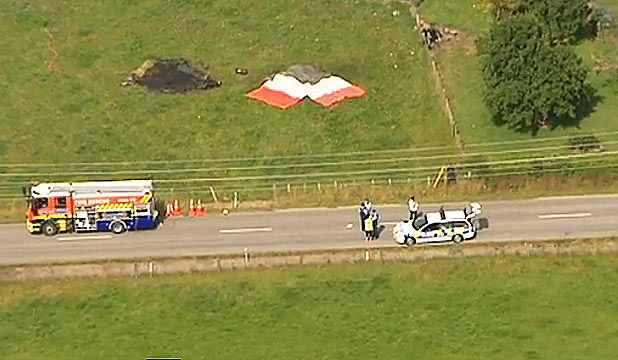 TRAGEDY: Firefighters, ambulance staff and police next to the paddock where the burning balloon crashed outside Carterton.  Photo: TV ONE.