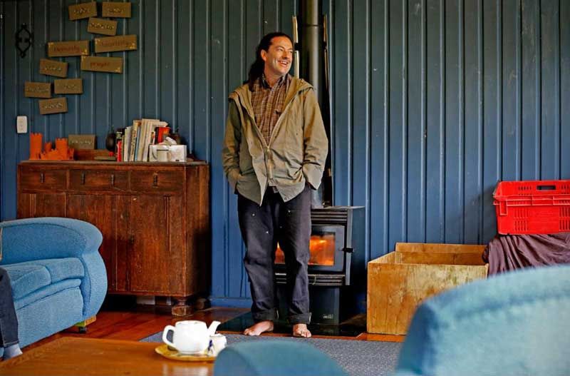 The “barefoot bishop” stands in front of the fire. — PHIL REID/Fairfax NZ.