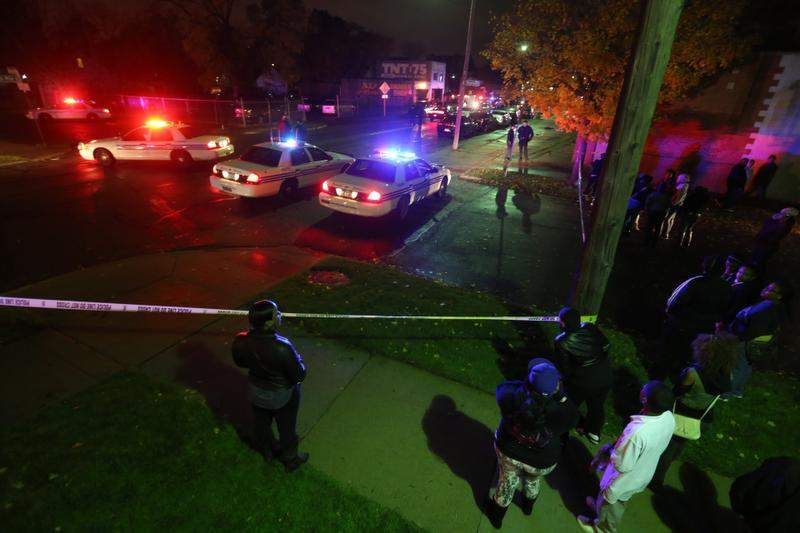 A small crowd gathers near a scene of a multiple shooting near Al's Place on 7 mile on Wednesday, November 6th, 2013, in Detroit. — Photo: Andre J. Jackson/Detroit Free Press.