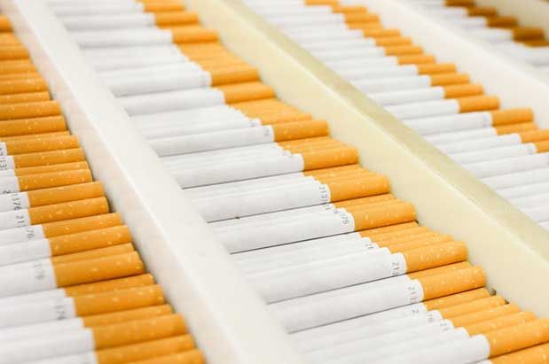 Newly made cigarettes lie in a tray ready for packaging at Imperial Tobacco.  Photo: Hagen Hopkins.