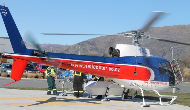 CHOPPER DOWN: An injured man is taken from a helicopter to the Wanaka Medical Centre. Six of the seven people onboard a helicopter that crashed on Mount Alta near Wanaka at 12.20pm on Saturday were injured. One person died.  CHE BAKER/Fairfax NZ.