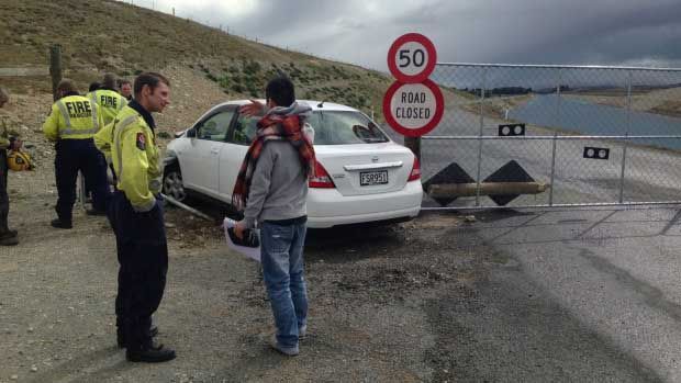 DOESN'T FIT: A Taiwanese man explains to an emergency services volunteer how his car ended up off-road and crashing into a cycle barrier on the Tekapo Canal Road.