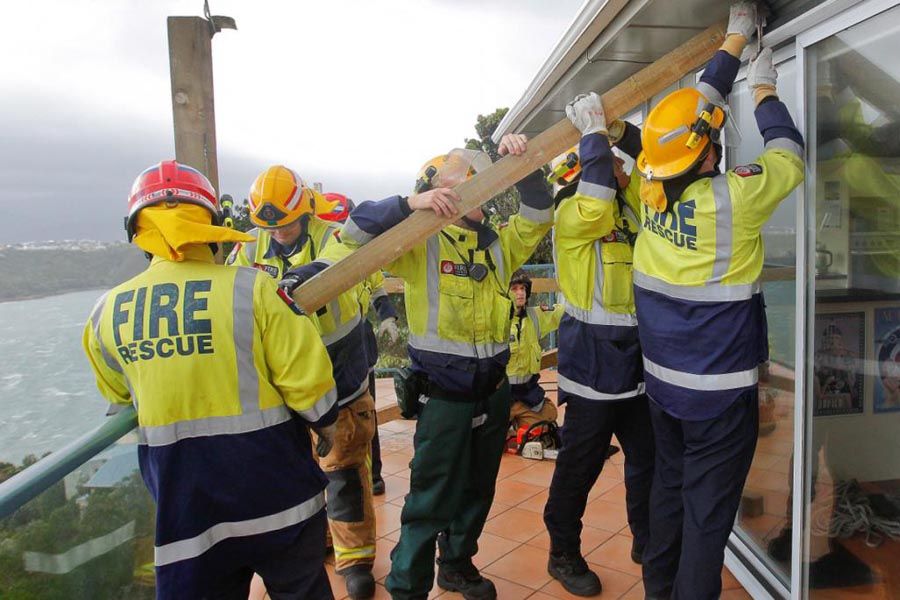 Fire fighters work to stabilise a veranda damaged by strong winds in Roseneath.  KEVIN STENT/Fairfax NZ.