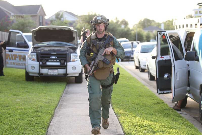 A member of the Harris County Sheriff's Department walks the scene of a standoff in Spring, Wednesday, July 9, 2014. — Photo: Brett Coomer/Houston Chronicle.