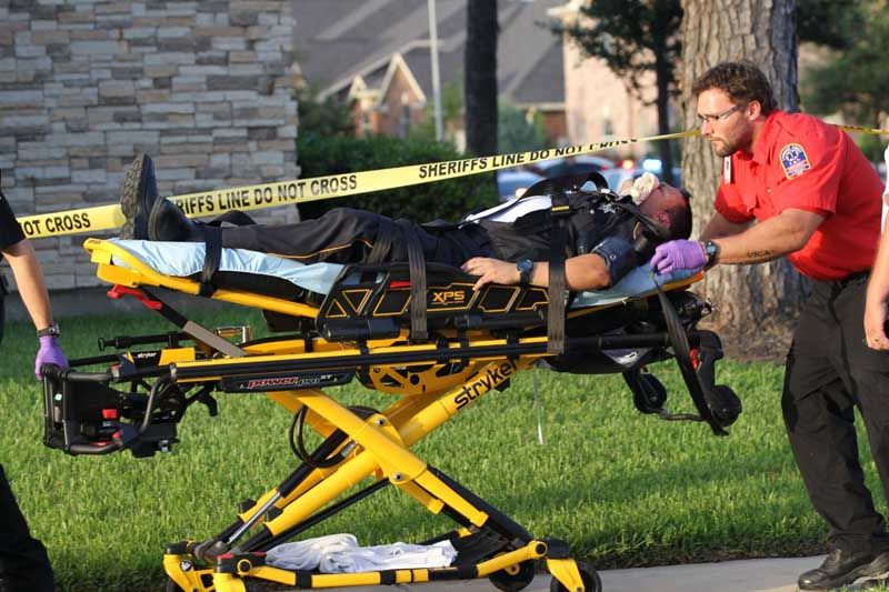 A law enforcement officer is taken to an ambulance, reportedly suffering from heat stroke, following a shooting Wednesday, July 9th, 2014, in Spring. Seven people were shot, with six confirmed dead. — Photo: Brett Coomer/Houston Chronicle.