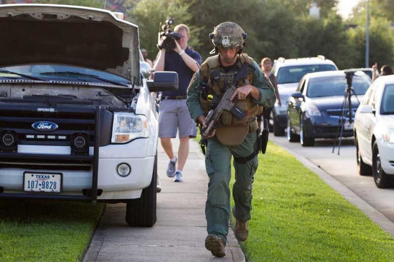 A law enforcement officer gears up for a standoff with a shooting suspect following a shooting Wednesday, July 9th, 2014, in Spring. Seven people were shot, with six confirmed dead. — Photo: Brett Coomer/Houston Chronicle.