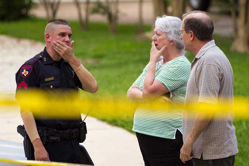 People stand with a law enforcement officer near the scene of a shooting Wednesday, July 9th, 2014, in Spring. Seven people were shot, with six confirmed dead. — Photo: Brett Coomer/Houston Chronicle.