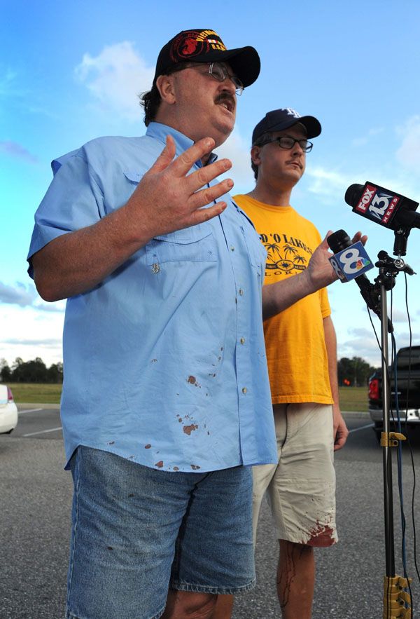 From left, Charles and Alex Cummings talk about what they saw in the theater. Both had blood on their clothes from trying to help the victims.  Photo: Cliff McBride/The Tampa Herald.