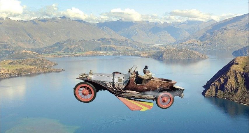 A mystery pilot waves as Chitty Chitty Bang Bang, on loan from Sir Peter Jackson, soars over Lake Wanaka yesterday.  Photo: Stephen Jaquiery.