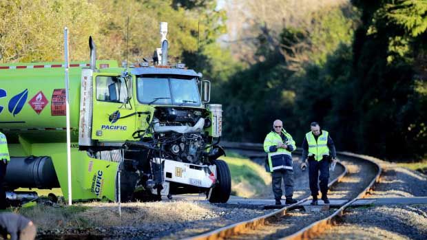 Emergency services workers survey the damage after a tanker truck collided with a train in Inglewood this afternoon, destroying the front part of the cab. The driver was uninjured.  Photo: Robert Charles/Fairfax NZ.