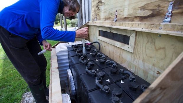 Liz Brook maintains her power house, the batteries which store her solar-sourced electricity.  Photo: Murray Wilson/Fairfax NZ.