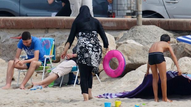 A Muslim woman wears a burkini, a swimsuit that leaves only the face, hands and feet exposed, on a beach in Marseille, France.  Photograph: Reuters.