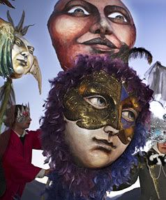 MASKER'S AIDE: Donna De Mente, of Oamaru, centre, and her colourful masks, gathered together for the Queenstown Festival Mardi Gras parade in Queenstown Bay last night. — BARRY HARCOURT/The Southland Times.
