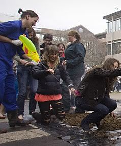 DOWN AND DIRTY: Massey University third-year veterinary student Zara Ballance sprays soft drink at horse-poo-covered first-year students, as part of the vet school initiation ritual. — BEN CURRAN/Manawatu Standard.