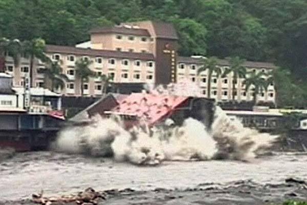 The toppling hotel hits the water. — Associated Press/ETTV Television.