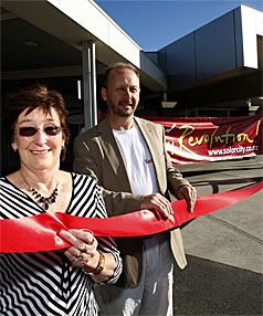 BEACH FRONT: Kaye McNabb, general manager for Nelson Airport, and Andy Booth, of Nelson company SolarCity, with a red ribbon that signifies the predicted rise in sea levels over the next 100 years and the impact it will have on Nelson Airport which is less than one metre above the present sea level. — MARTIN DE RUYTER/The Nelson Mail.