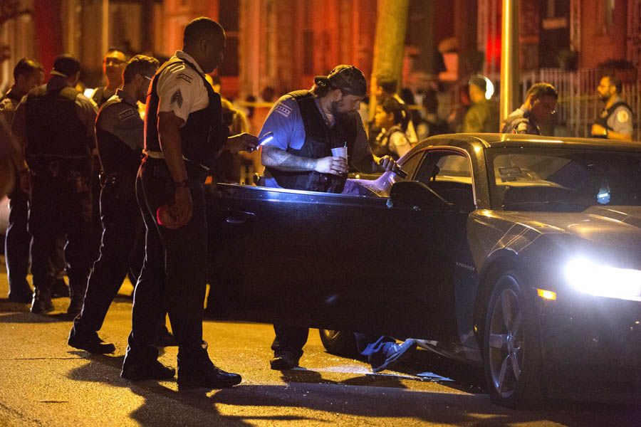 Members of the Chicago Police Department look inside a vehicle involved in a shooting in the 3300 block of West Flournoy Street on September 5th, 2016, in the Homan Square neighborhood. A man and woman were both shot inside the parked car and were taken to Mount Sinai Hospital. — Photograph: Erin Hooley/Chicago Tribune.