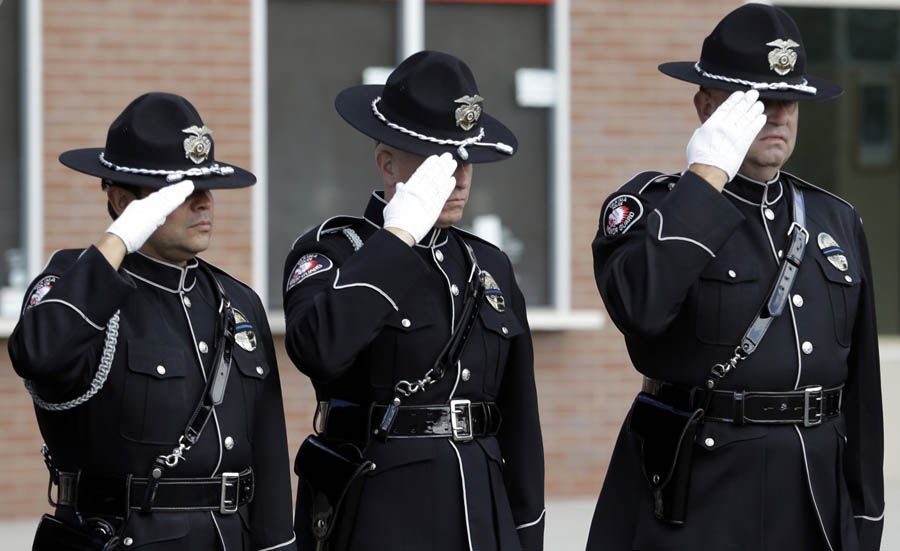 Firefighters salute as a motorcade passes before a memorial service on August 30th in Wenatchee, Washington, for three firefighters killed in a wildfire. Richard Wheeler, Andrew Zajac and Thomas Zbyszewski died on August 19th in the fire near Twisp, Washington. — Photograph: Elaine Thompson/Associated Press.