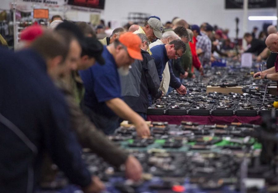 People look at handguns at the Nation's Gun Show at the Dulles Expo Center earlier this month. — Photograph: Jabin Botsford/The Washington Post.