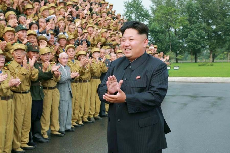 North Korean leader Kim Jong Un claps his hands during a photo session with participants of the Fourth National Conference of War Veterans in front of the Fatherland Liberation War Martyrs Cemetery in this undated photo released by North Korea's Korean Central News Agency (KCNA) on July 30th, 2015.