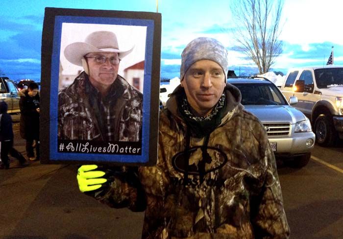 Tony Atencio holds a photo of rancher Robert “LaVoy” Finicum at a rally protesting against the federal government in Burns, Oregon. The funeral for Finicum, killed by law enforcement during the armed occupation of an Oregon wildlife refuge was expected to draw supporters on Friday, February 5th, from around the West to a small Utah town. — Photograph: Nicholas K. Geranios/Associated Press.