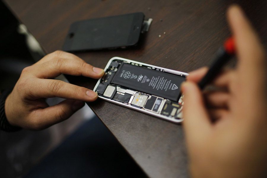 A worker tries to fix an iPhone in a repair store in New York on February 17th, 2016.  Photograph: Eduardo Munoz/Reuters.