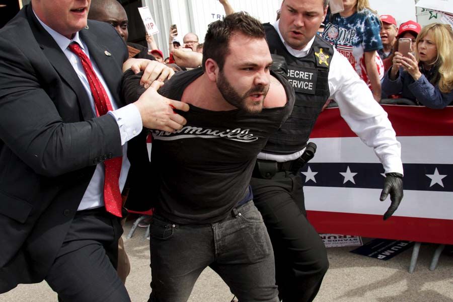 The man is led away from the rally by Secret Service agents. — Photograph: William Philpott/Reuters.